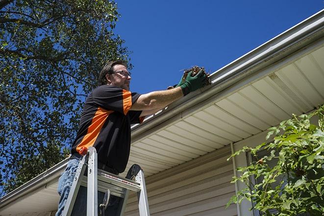 a gutter repair specialist fixing a leaky rain gutter in Sylvan Lake